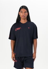 Black mesh athletic shirt with short sleeves; features red logo accents in the front and on the sleeves; paired with matching shorts.