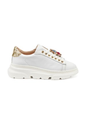 Sneaker bianco in pelle con suola chunky bianca, dettagli dorati e un particolare gioiello decorativo sui lacci. Tacco conico testurizzato dorato.