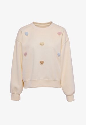Bluza dresowa w kolorze kremowym z długimi rękawami, ozdobiona małymi pastelowymi naszywkami w kształcie serc w niebieskim, żółtym, różowym i beżowym kolorze z przodu.