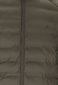 Mørkegrøn puffjakke med fuld længde lynlås, vandret syninger og et diskret logo på venstre side. Glat tekstur.