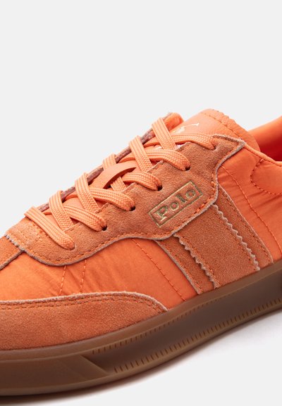 Πορτοκαλί αθλητικό παπούτσι Polo με πάνελ από σουέντ και νάιλον, κλείσιμο με κορδόνια και σόλα από καουτσούκ τύπου μόλας.