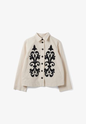 Giacca beige con bottoni e colletto, ricamo ornamentale nero simmetrico sul davanti e tasche laterali.