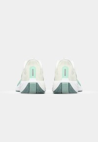 Sneakers in wit en mintgroen, met een gestructureerde bovenkant, een gevoerde zool en een opvallend hakontwerp met een verticale accent.