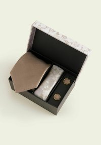 Braune strukturierte Krawatte, helles Einstecktuch mit Blumenmuster und goldfarbene Manschettenknöpfe in einer dekorativen Schachtel mit Blumendesign präsentiert.