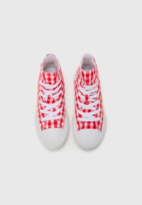 Rød og hvit rutete høyhælte sneakers med hvite gummisåler og snørebånd, med en glatt lerretsoverdel og rund tå.