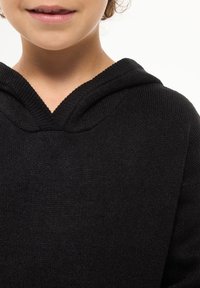 Czarny dzianinowy hoodie z dekoltem w serek i teksturowanym materiałem. Ubranie ma luźny krój i miękki kaptur.