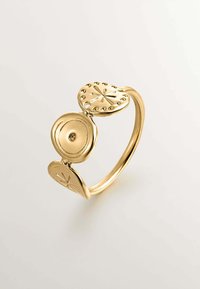 Anillo en tono dorado con una banda curva que presenta tres elementos en forma de óvalo. Dos de ellos tienen patrones decorativos y uno con una superficie lisa y reflectante.