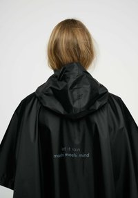 Musta vettä hylkivä poncho, jossa on huppu. Selässä valkoiset tekstit 'let it rain' ja 'moshi moshi mind'. Sileä, kevyt materiaali.