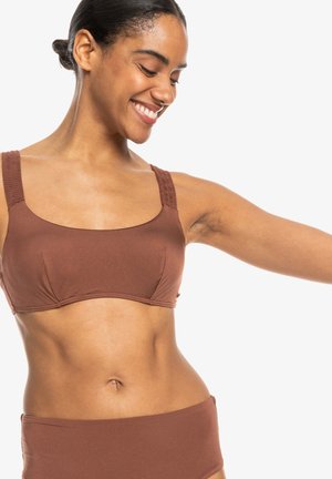 Hnedý bikini top s hranatým výstrihom a širokými ramienkami, s textúrovanými akcentmi. Hladká látka, priliehavý dizajn, v kombinácii s vysokými nohavičkami.