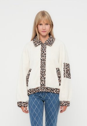 Veste en polaire blanche avec des accents en imprimé léopard sur le col, les poches et les poignets ; coupe décontractée avec des manches longues et une fermeture éclair.