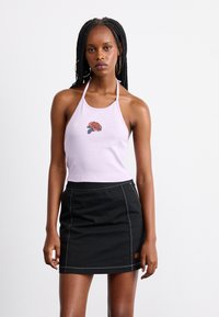 Top halter lilla con ricamo di rose al centro; abbinato a una mini gonna di jeans nera con cuciture a contrasto e una patch con logo.