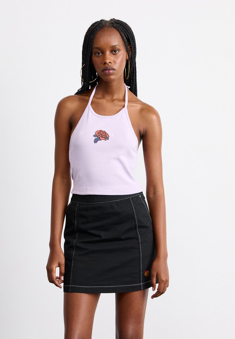 Top halter lilla con ricamo di rose al centro; abbinato a una mini gonna di jeans nera con cuciture a contrasto e una patch con logo.