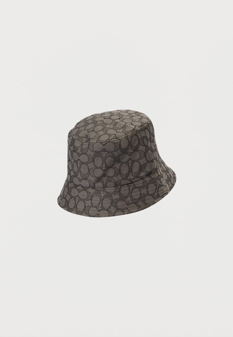 Chapeau bob en tissu tissé, présentant un motif circulaire en tons noir et gris. Texture douce avec un large bord incliné vers le bas.