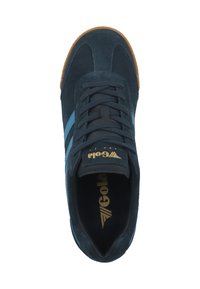 Sneaker blu in suede con suola in gomma color caramello, caratterizzato da strisce blu e logo dorato sulla linguetta e sulla soletta. Design della punta arrotondata.