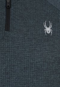 Pullover a mezzo zip di un verde scuro in tessuto testurizzato con righe verticali. Presenta una zip nera e un logo di ragno bianco sul petto.