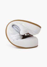 Scarpa bianca in pelle con design flessibile, forma arrotondata e suola in gomma marrone. Caratterizzata da un rivestimento interno morbido e dettagli di cucitura minimi.