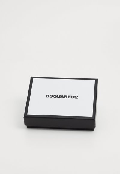 Crna kutija s poklopcem na šarku, s bijelim vrhom na kojem je uočljivo ispisano "DSQUARED2" u debelim crnim slovima. Glatka, mat završnica.