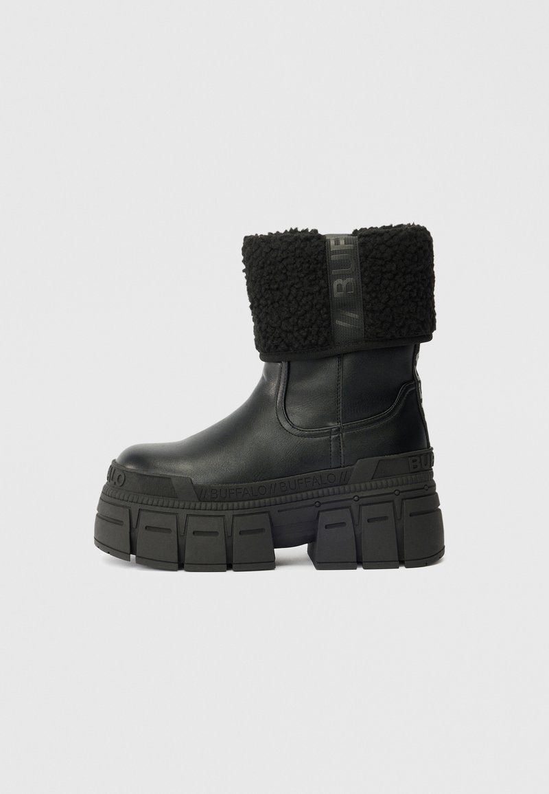 Bota de tornozelo preta em couro com sola de plataforma grossa e punho de pelo dobrável rotulada "BUFFALO" na tira e na sola.