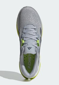 Vue de dessus d'une chaussure de sport grise et vert néon avec lacets et tige en tissu texturé, montrant un col rembourré et une semelle intérieure estampillée.