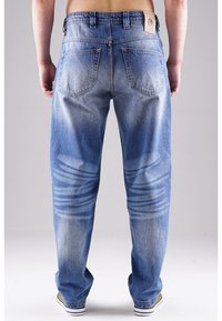 Jasnoniebieskie dżinsy z denimu o luźnym kroju, z wyblakłymi partiami, pięcioma kieszeniami oraz metką na pasku od spodni.