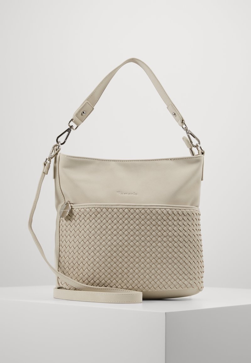 Sac à main beige avec un dessus lisse et un panneau inférieur tissé. Dispose d'une sangle ajustable unique et d'une poche zippée. Accents en métal argenté.