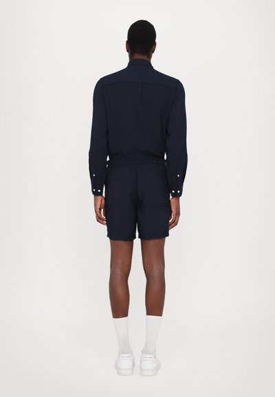 Mørkeblå skjorte og shorts sett, med kragehals, lange ermer, knappemanchetter og en avslappet passform med elastisk midje.