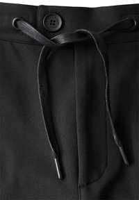 Svarta sweatpants med en slät yta, med dragsko-öppning och metallaccent i midjan.