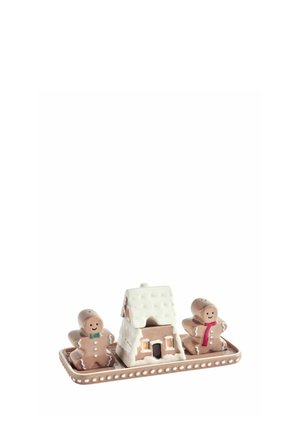 Two gingerbread man salt and pepper shakers with a gingerbread house between them on a rectangular tray with white icing details.