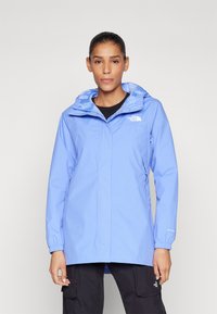 Šviesiai mėlynas vandeniui atsparus džinsinis švarkas su kapišonu, reguliuojamomis rankovėmis ir užtrauktuku priekyje. Priekyje yra "The North Face" logotipas.
