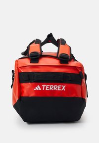 Röd och svart Terrex-ryggsäck med vattentåligt material. Har robusta justerbara remmar och en framlomme med logodetalj. Kompakt form.