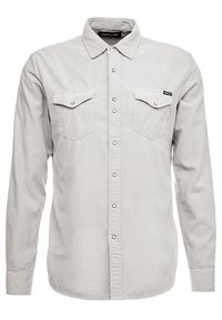 Camicia grigia a bottone realizzata in tessuto morbido, con due tasche sul petto con pattina, colletto a punta e maniche lunghe con polsini abbottonati.