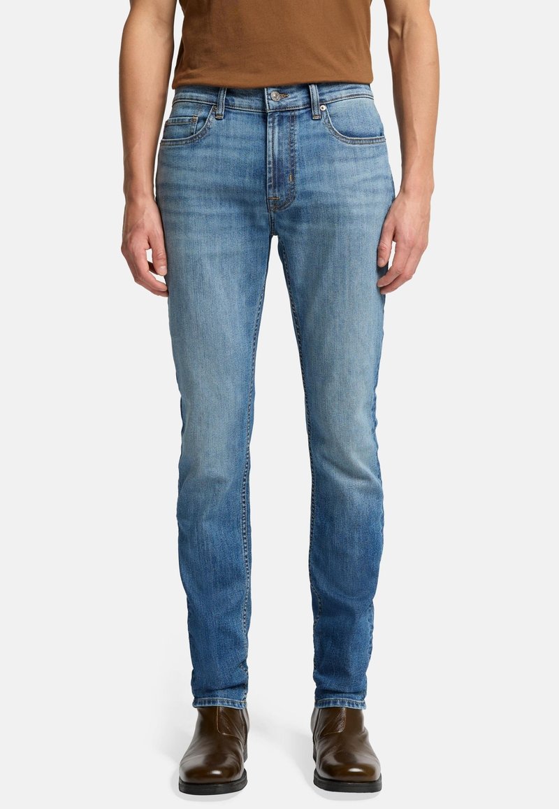 Jeans in denim blu chiaro con vestibilità slim, cinque tasche e leggera sfumatura. La vita presenta una chiusura con bottone e passanti per la cintura.