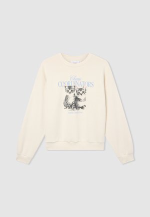 Felpa color crema con collo rotondo e maniche lunghe, caratterizzata da una grafica stampata di due gattini e dal testo "Coordinatori del Caos".