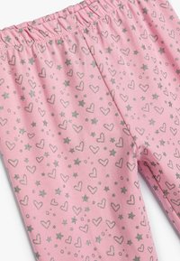 Pink leggings with an elastic waistband, featuring a pattern of silver hearts and stars on a soft, textured fabric.