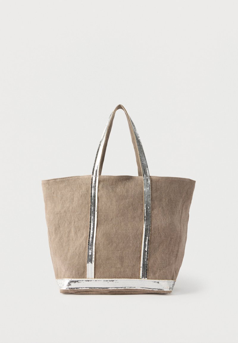 Καφέ υφασμάτινη τσάντα tote με ασημένιες παγιέτες στα χερούλια και στη βάση. Ευρεία, ορθογώνια μορφή με στιβαρά, ίσια χερούλια.