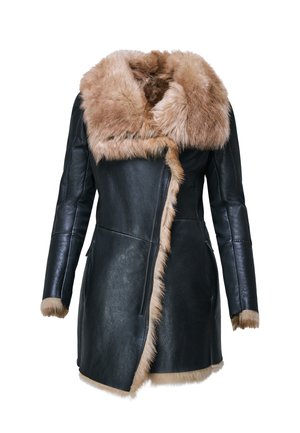 Femme portant un manteau en cuir noir avec bordure en fourrure marron, tenant un sac à main en fourrure assorti et portant des bottes hautes noires à talons jusqu'au genou.