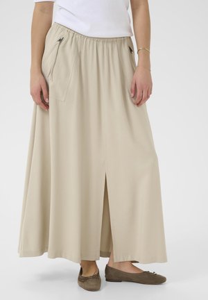 Gonna maxi beige con vita elastica arricciata, dotata di due tasche laterali e uno spacco frontale, realizzata in tessuto morbido e fluido.