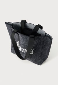 Svart filt tote-väska med en strukturerad design, med två svarta handtag och vit text. Slät yta med ett subtilt mönster.