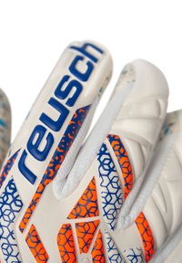 Guanti da portiere realizzati in un materiale sintetico bianco con motivi geometrici blu e arancioni, dotati di grip imbottito e del logo "reusch" ben visibile.