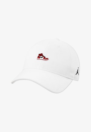 Gorra de béisbol blanca con visera curva, con un logotipo bordado de una zapatilla en rojo y negro en el frente y un pequeño logotipo negro en el lateral.