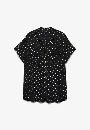 Blouse noire à manches courtes avec des pois blancs, boutons sur le devant, deux poches poitrine et pattes de manches boutonnées, posée à plat sur un fond blanc.