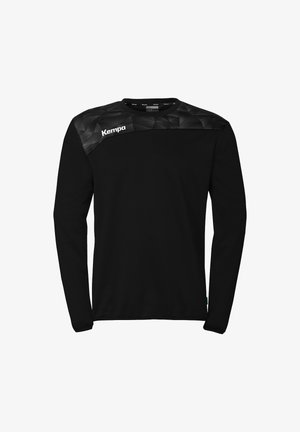Black long-sleeve sports shirt with geometric pattern on shoulders and white Kempa logo on the upper left chest.