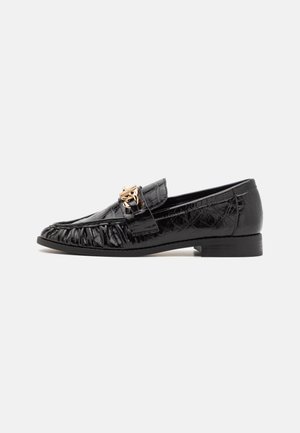 Black patent leather loafers with a textured finish, ruffled front detailing, and a gold-tone hardware accent. Low, flat heel.