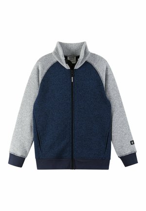 Giacca blu navy e grigia con zip, colletto alto, maniche raglan e tessuto testurizzato. Presenta polsini elastici e un logo sulla manica.