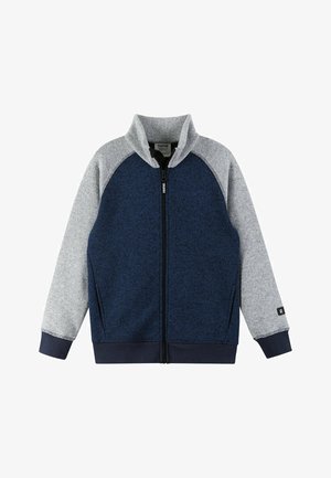 Giacca blu navy e grigia con zip, colletto alto, maniche raglan e tessuto testurizzato. Presenta polsini elastici e un logo sulla manica.