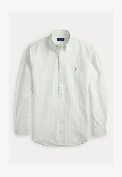 Chemise blanche à manches longues boutonnée avec fines rayures verticales vertes, col à boutons et petit logo cheval brodé sur la poitrine gauche.