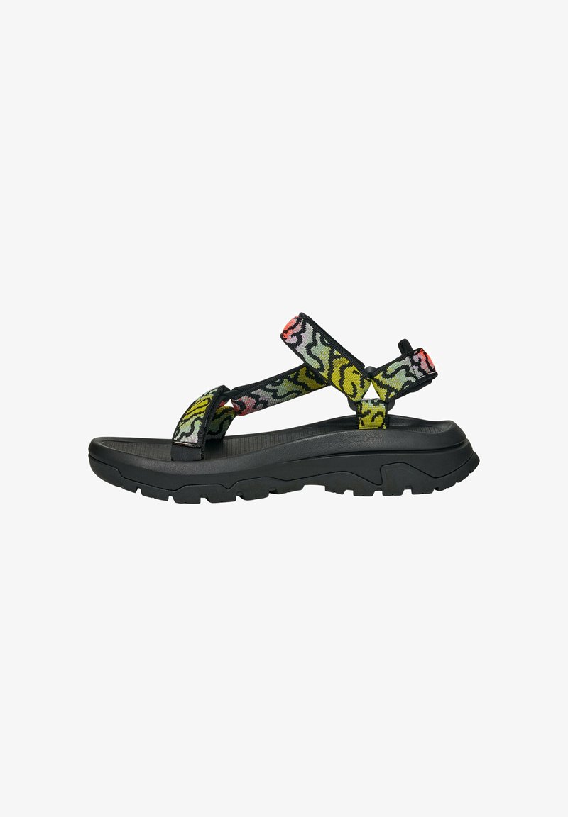 Sandale à semelle épaisse noire avec des sangles en tissu multicolores arborant un motif floral et des fermetures ajustables. Semelle intérieure texturée pour le confort.
