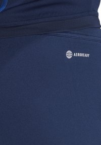 Marine sportshorts van een gladde, rekbare stof, met een zichtbaar 'AEROREADY' logo in het wit aan de onderzijde.