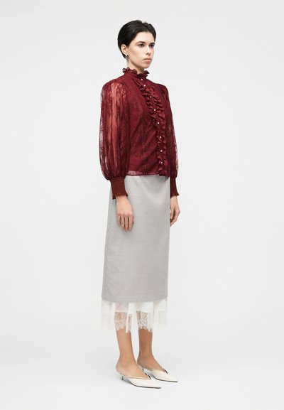 Vínová čipkovaná blúzka s volánikmi vpredu a nadýchanými priesvitnými rukávmi, skombinovaná so svetlosivou ceruzkovou sukňou s bielym čipkovým lemom a bielymi mulemi.