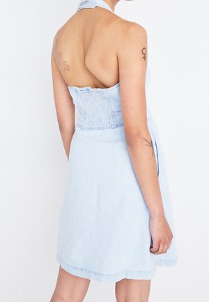 Abito in denim blu chiaro con corpetto arricciato, scollatura a halter e gonna svasata. Presenta un design senza schiena e dettagli sottili nell'orlo.